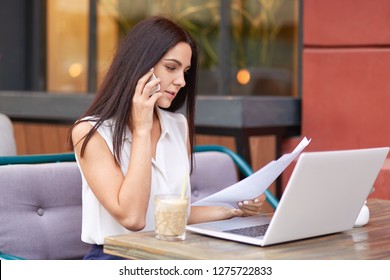 Businesswoman Has Telephone Conversation, Studies Business Documentation, Financial Analysis, Sits In Front Of Opened Laptop Computer, Drinks Cocktail, Poses In Outdoor Cafeteria, Surfes Online