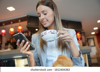 Businesswoman having breaksfast at train station cofffee shop