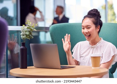 Businesswoman Having Video Call On Laptop At Table In Breakout Seating Area Of Office Building