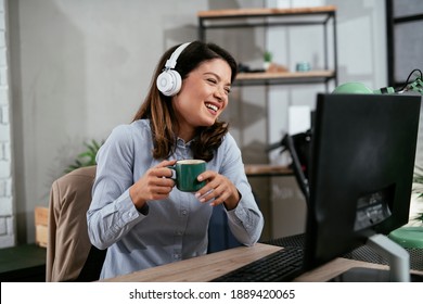 Businesswoman with headphones having video call on computer. Beautiful woman having meeting online.