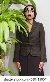 Businesswoman Hiding Behind Plant Wearing Disguise