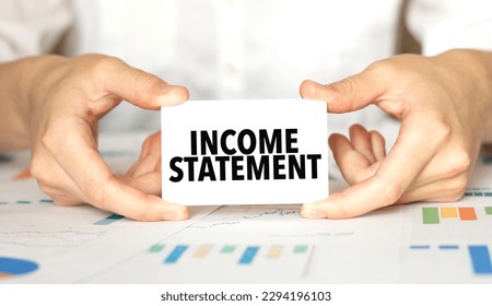 Businesswoman holding a card with text income statement - Shutterstock ID 2294196103