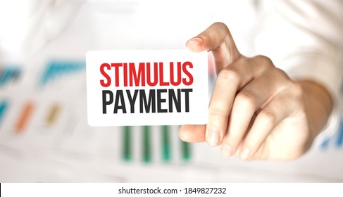 Businesswoman Holding A Card With Text STIMULUS PAYMENT