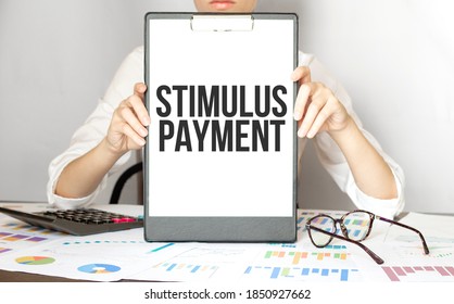 Businesswoman Holding A Card With Text STIMULUS PAYMENT