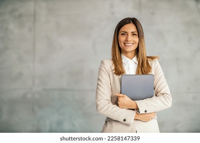 Businesswoman holding digital tablet.People,business and technology concept.She is looking at camera. - Powered by Shutterstock