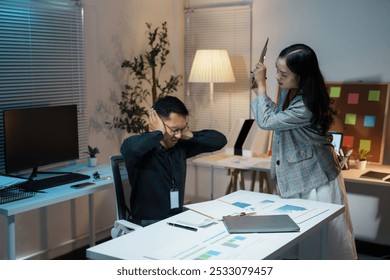 Businesswoman holding a folder is screaming at a stressed businessman covering his ears with his hands while working late in the office - Powered by Shutterstock