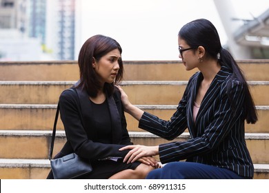 Businesswoman holding hand on shoulder of colleague, consoling for help and support which her friend suffering in the step office - Powered by Shutterstock