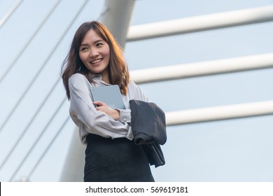 Businesswoman holding tablets and smiled happily. - Shutterstock ID 569619181