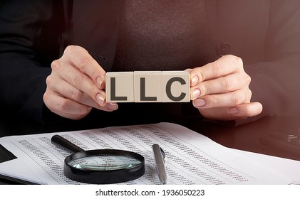 businesswoman holding wooden block with text LLC , business