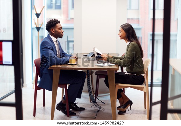 Businesswoman Interviewing Male Job Candidate In\
Meeting Room