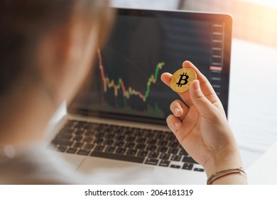 Businesswoman, investor, trader hold Bitcoin Cryptocurrency, using computer laptop with graph chart, trading stock market, investing Bitcoin cryptocurrency at home. Investment and technology concept. - Powered by Shutterstock