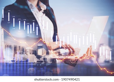 Businesswoman with laptop and economic crisis stock charts on city background. Trade and finance depression concept