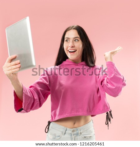 Businesswoman with laptop. Love to computer concept. Attractive female half-length front portrait, trendy pink studio backgroud. Young emotional pretty woman. Human emotions, facial expression