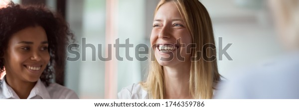Businesswoman leader laughing at funny joke at\
group meeting with diverse colleagues. Team building workshop\
activity, good relations at work concept. Horizontal photo banner\
for website header\
design