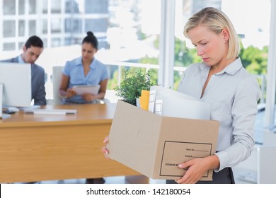 Businesswoman Leaving Office After Being Laid Off Carrying Box Of Belongings