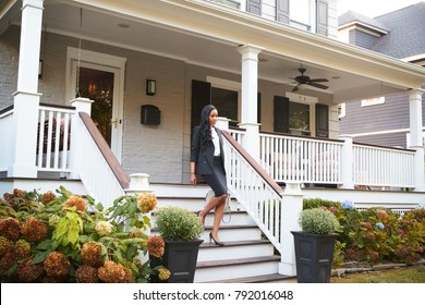 Businesswoman Leaving Suburban House For Commute To Work