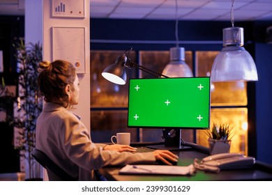 Businesswoman looking at green screen chroma key mock up computer with isolated display, working overtime at company strategy in startup office. Executive manager analyzing financial report growth - Powered by Shutterstock