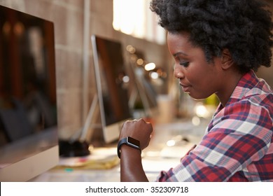 Businesswoman Looking At Smart Watch In Design Office - Powered by Shutterstock