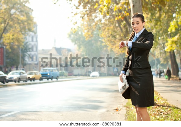 businesswoman looking in watch,  late for work or\
a meeting