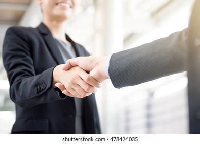 Businesswoman making handshake with a businessman -greeting, dealing, merger and acquisition concepts