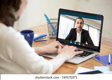 Businesswoman making video call to business partner using laptop. Close-up rear view of young woman having discussion with corporate client. Remote job interview, consultation, online meeting concept. - Shutterstock ID 749570371