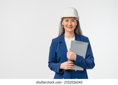 Businesswoman mature female construction worker, engineer, architect in formal suit looking at camera in protective hard hat holding clipboard isolated in white background. Real estate agent - Powered by Shutterstock