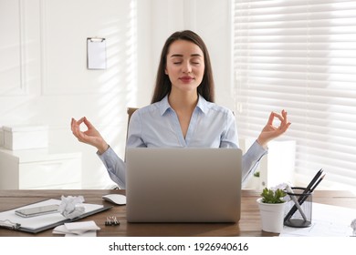 Businesswoman meditating at workplace in office. Stress relieving exercise - Powered by Shutterstock