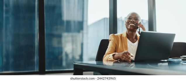 Businesswoman in a modern office, using her laptop and speaking on the phone. She is confident and successful, dressed in corporate attire. Woman communicating with her associates using technology. - Powered by Shutterstock