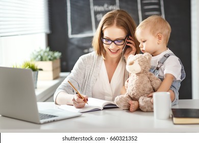 Businesswoman mother  woman with a toddler working at the computer