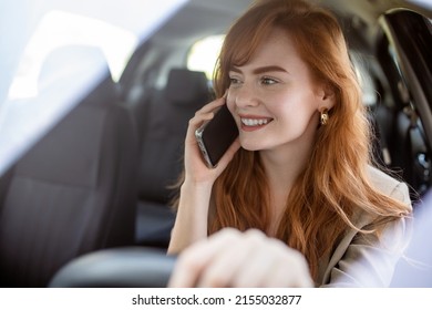 Businesswoman Multitasking While Driving, Talking On The Phone. Smiling Woman Talking On Her Phone While Driving. Woman Talking On Mobile While Driving