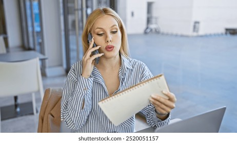 A businesswoman multitasks with a smartphone and notebook outdoors in a blurred urban setting. - Powered by Shutterstock