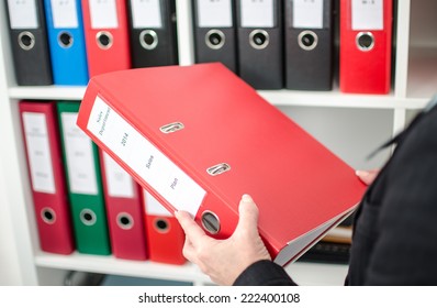 Businesswoman At Office Holding A Red Folder