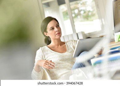 Businesswoman in office working on digital tablet - Powered by Shutterstock