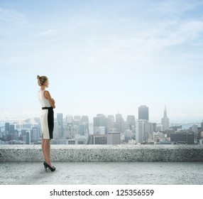 businesswoman on roof looking at city - Powered by Shutterstock