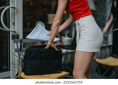 Businesswoman organizing financial documents and notes for a meeting, highlighting preparation and professionalism in a modern office setting. - Powered by Shutterstock