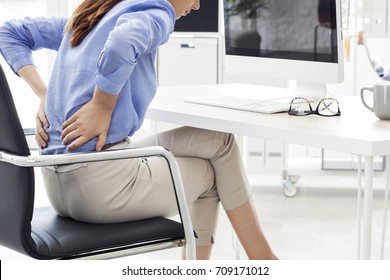 Businesswoman with pain in back  - Shutterstock ID 709171012