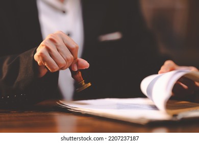 businesswoman person's hand stamping with approved stamp on certificate document public paper at desk, people work in notary law or business finance agreements, lawyer paperwork in confidential