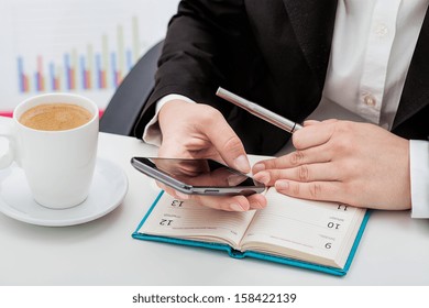 Businesswoman with phone, calendar and a coffee