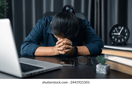 Businesswoman praying at work. Contemplative prayer thinking in office. Hands folded in prayer gesture beg about something. woman with hands clasped praying while sitting at desk in office. - Powered by Shutterstock