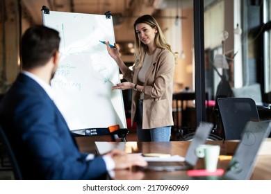 Businesswoman present her idea to working team. Young beautiful woman presenting businessplan - Powered by Shutterstock