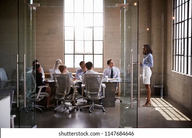 Businesswoman presenting to colleagues at boardroom meeting