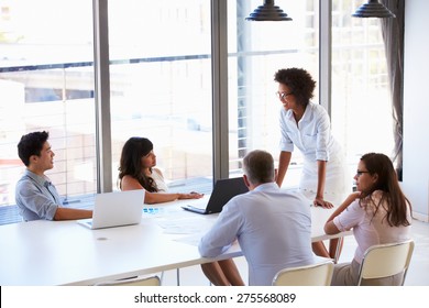 Businesswoman presenting to colleagues at a meeting - Shutterstock ID 275568089