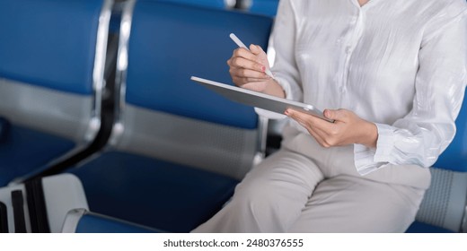 Businesswoman Professional Using Digital Tablet at Modern Airport Lounge for Work and Communication - Powered by Shutterstock