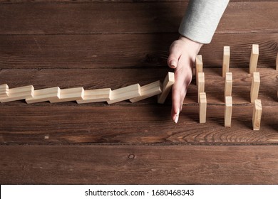 Businesswoman Protecting Dominoes From Falling On Wooden Desk. Business Assistance And Leadership In Crisis. Operative Business Solution And Stabilization Of Situation. Professional Risk Management