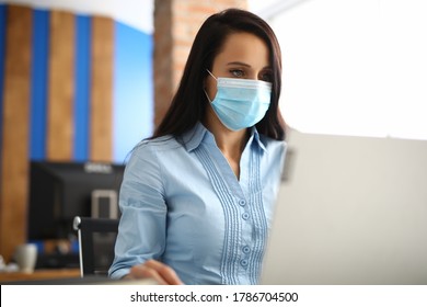 Businesswoman In Protective Medical Mask Is Sitting In Office. Health Safety In The Workplace Covid -19 Concept