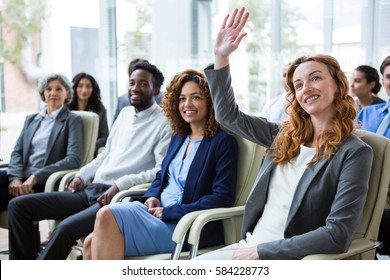 Businesswoman Raising Hand During Meeting In Office