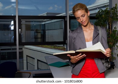 Businesswoman Reading Book In Office