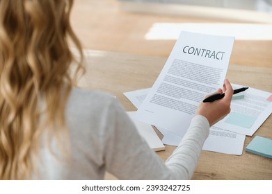 Businesswoman reading contract before signing. Making financial business deal, sale and purchase transaction. Concept of application form for mortgage, loan, buy or rent house. Important papers. - Shutterstock ID 2393242725
