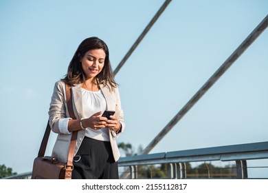 Businesswoman reading her smart phone in the street. Copy space