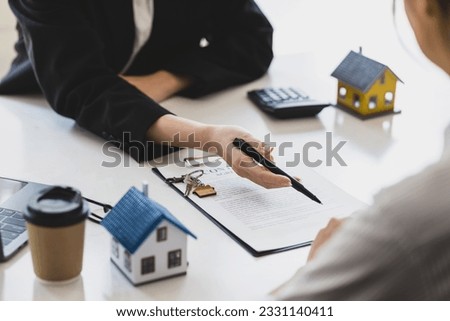 Businesswoman, real estate agent discussing the terms of the house purchase agreement contract document and letting the client sign legally, mortgage, rent, insurance. Stockfoto © 